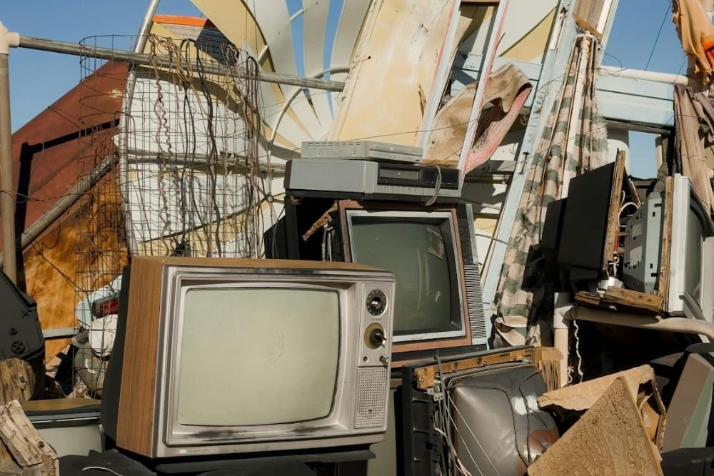 A cluttered heap of outdated televisions and junk, highlighting WE Waste Junk Removal Service in Honolulu, HI.