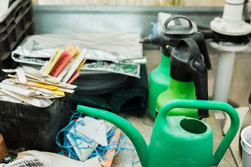 Three green watering cans arranged on a table, highlighting an indoor junk removal service in Honolulu, HI.