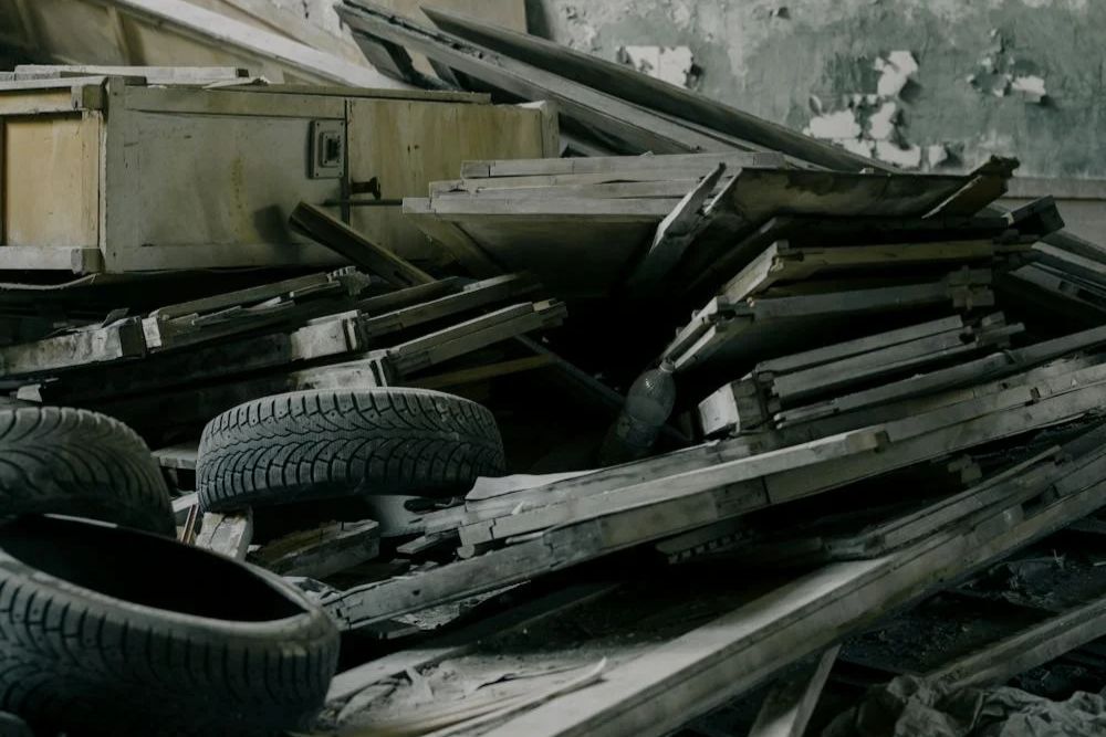 A room filled with a disorganized pile of tires and assorted items, representing a junk removal service in Honolulu, HI.